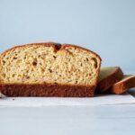 رغيف خبز موز منزلي ذهبي ورطب مع شرائح موز محمّصة