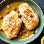 Skillet chicken piccata in a bright lemon caper sauce, fresh herbs over a sizzling skillet.