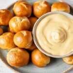 لدغات بريتزل طرية غير قابلة للمقاومة مع صوص جبن كريمي لذيذ، تفاصيل ذهبية مبهجة.