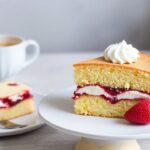 لقطة لكيكة فكتوريا الإسفنجية الكلاسيكية بطبقات مربى وكريمة كريمية، تفاصيل شهية للحلوى.