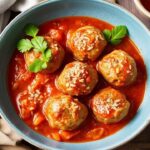 Porcupine meatballs simmering in classic tomato sauce in a cozy bowl.