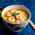 Green curry ramen with coconut shrimp delight, a flavorful bowl.