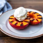 Grilled peaches with honey and ice cream, a sweet summer treat.